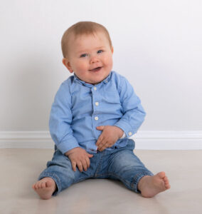 Toddler wearing jeans sitting on floor