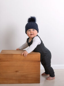 Toddler with beanie holding wooden box